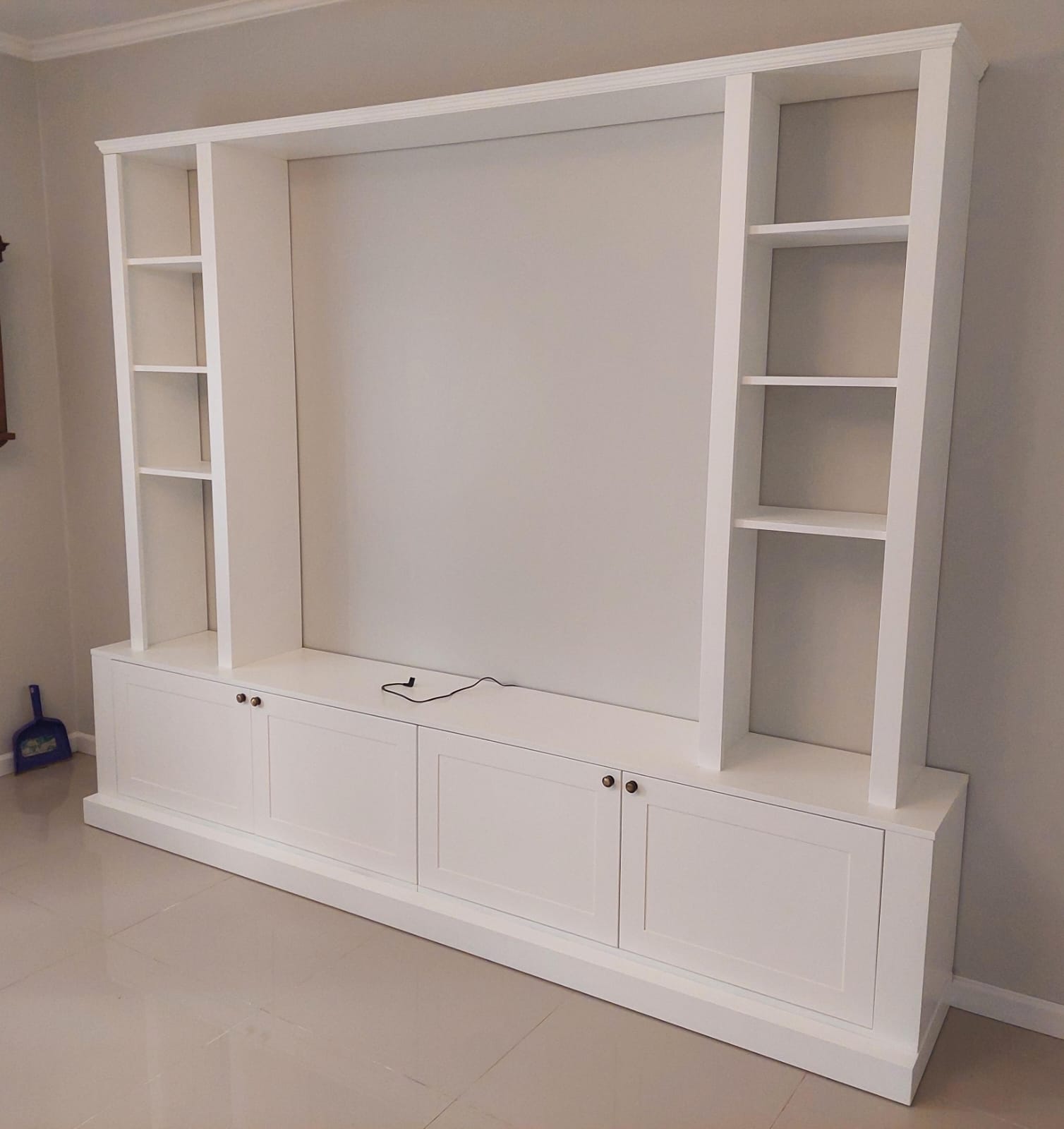 Mueble de living blanco con biblioteca